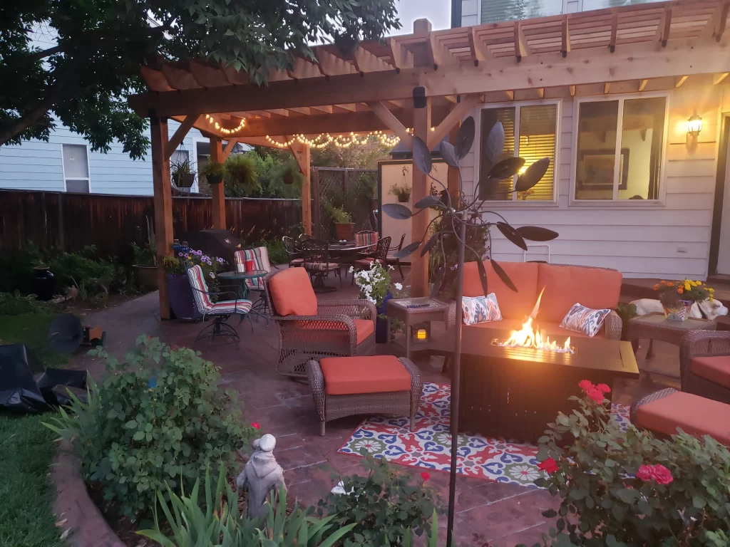Backyard patio lit with string lights under a pergola for evening outdoor dining