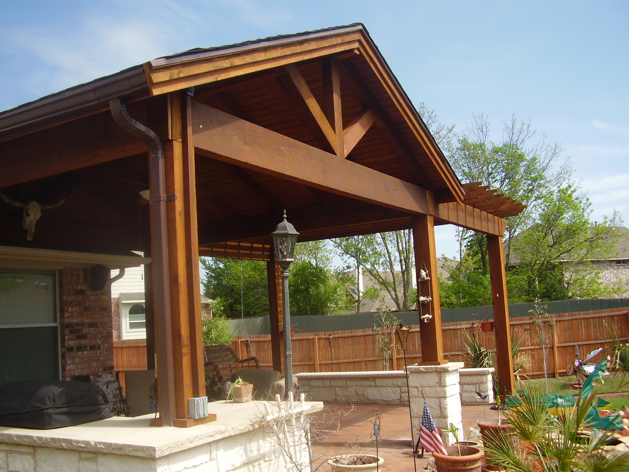 Wood-framed patio cover with a pitched roof over a Colorado backyard patio
